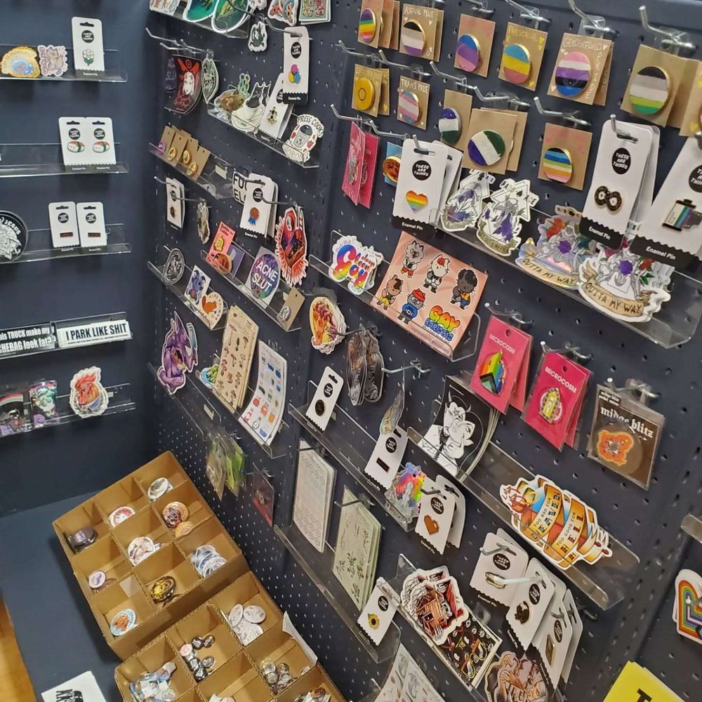 Photo of the sticker corner with lots of cool stickers, enamel pins, pinback buttons, etc.