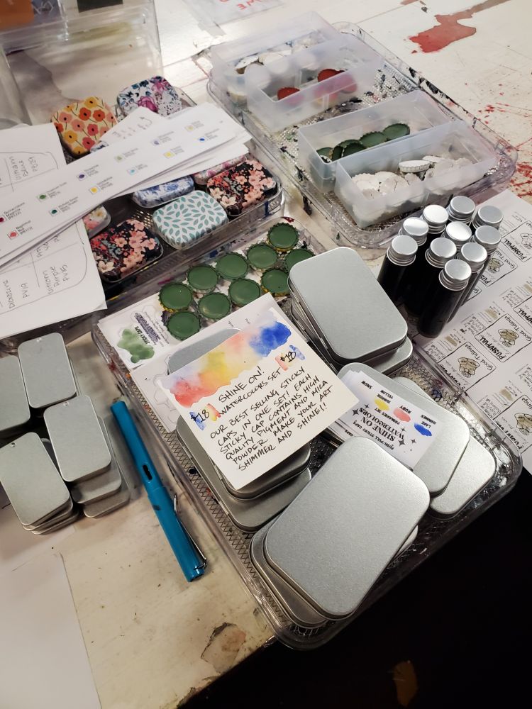 A bunch of in progress watercolor palettes in various states of assembly at the front counter.