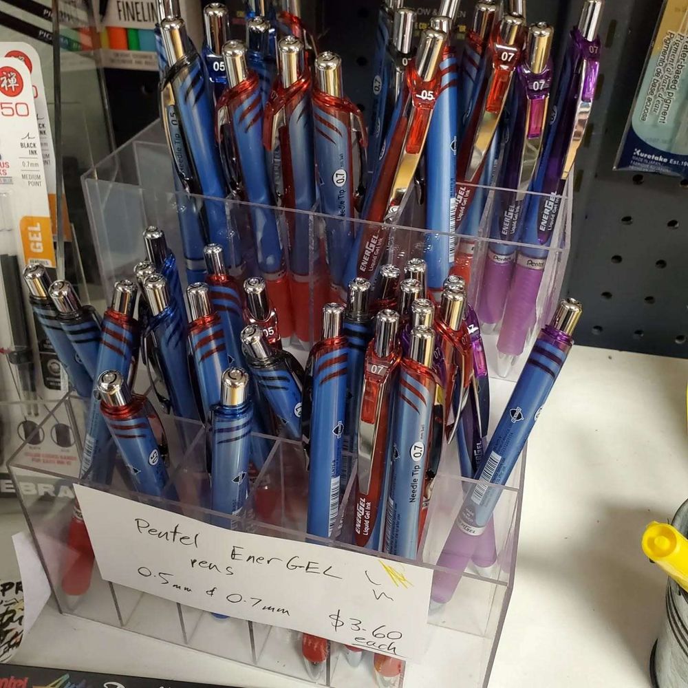 Display of Pentel EnerGEL pens, 0.5mm and 0.7mm, $3.60 each, as described by the handwritten sign.