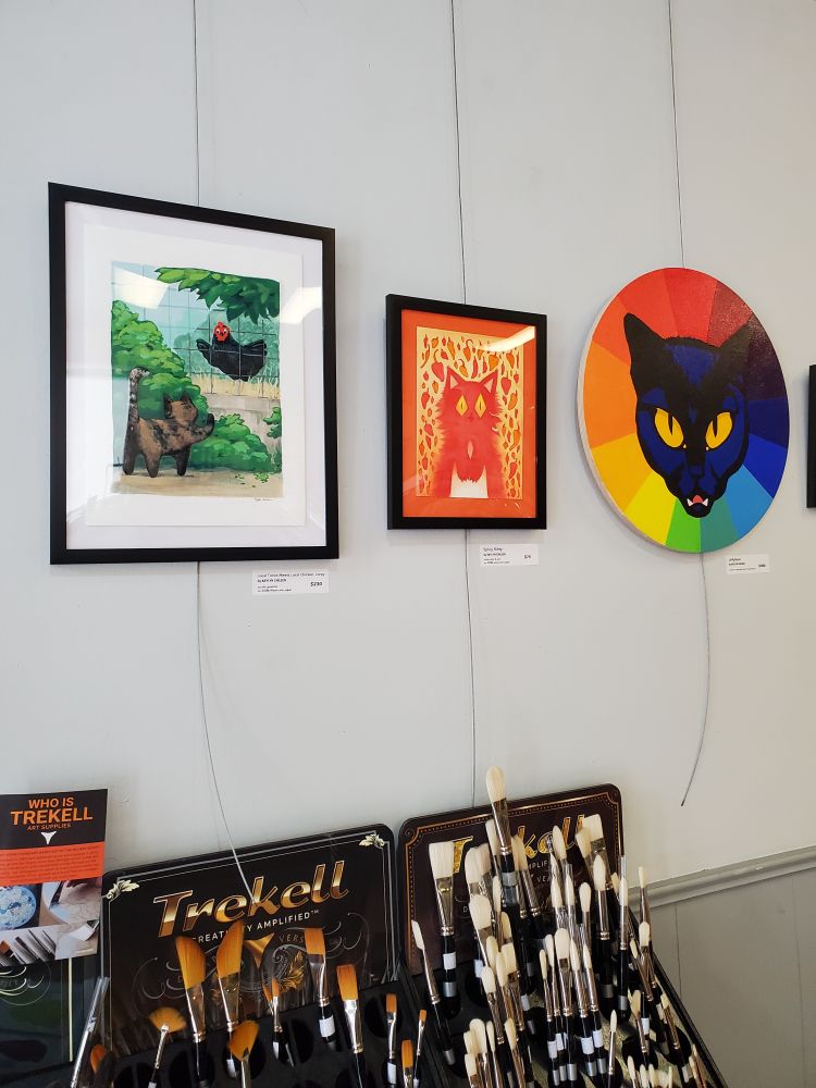 Three pieces of cat art hanging on a wall.