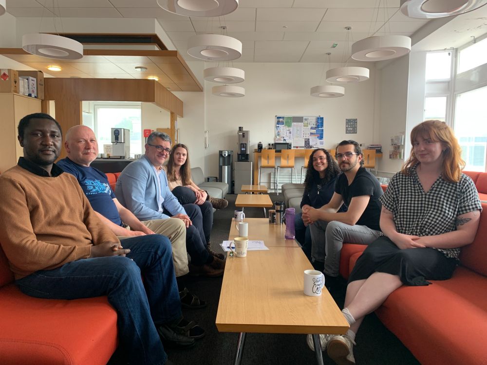 OSC members having Coffee with Prof Troisi. Front to back - left: Edward, Arvydas, Prof Troisi, Eglė. Front to back - right: Maddie, Saban, Michele.

