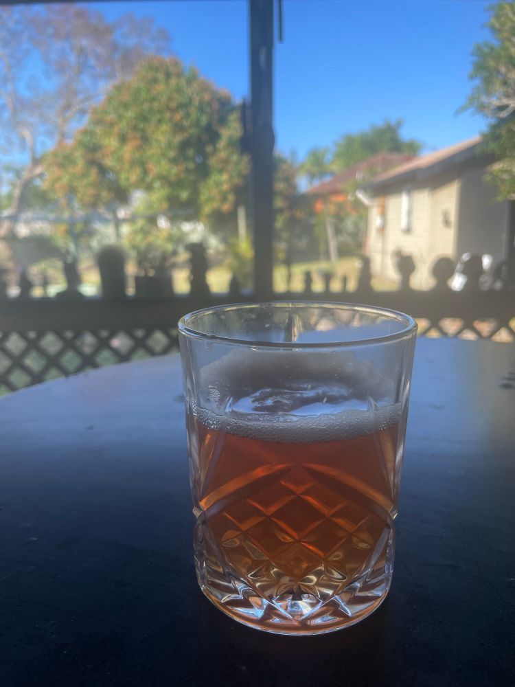 Sangiovese gin and tonic in a crystal tumbler on a black metal table, background yard and spooky decorations 