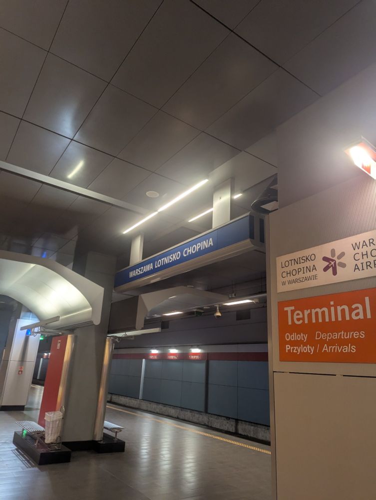 A sign at a railway station saying "Warszawa Lotnisko Chopina" i e. Warsaw Chopin Airport