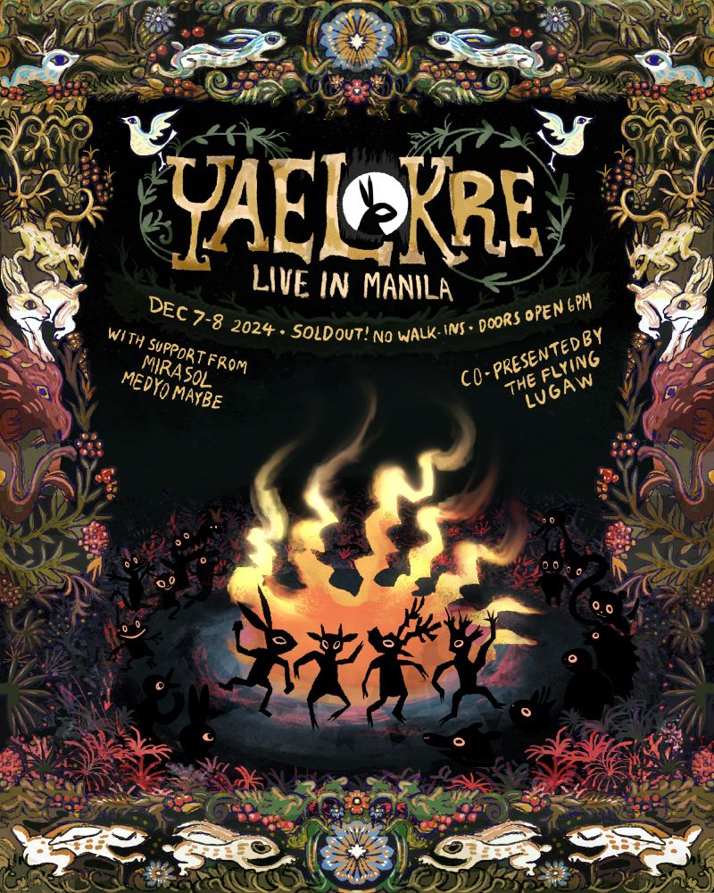 A crowd of animals dancing around a fire, with the moon shining down on them. The scene is bordered by a wooden frame that contains different woodland animals and plants.