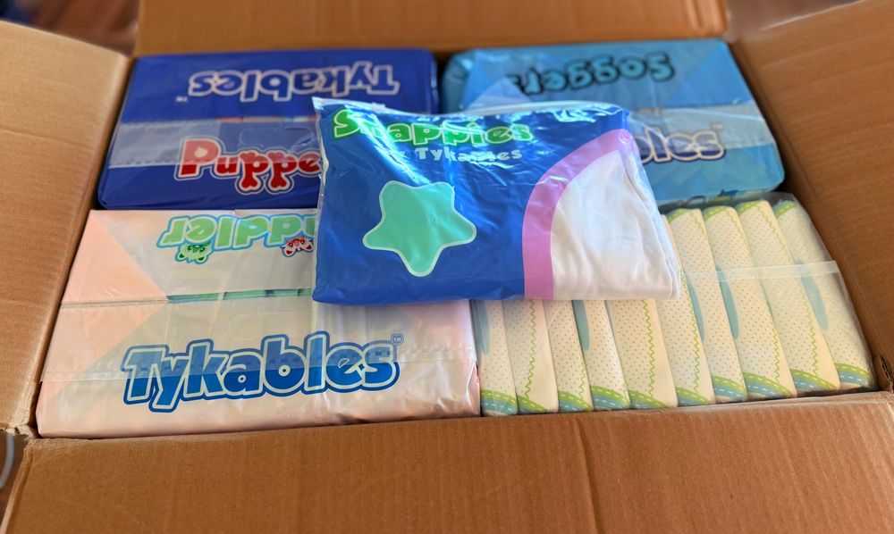 An open cardboard box showing a variety of adult diapers