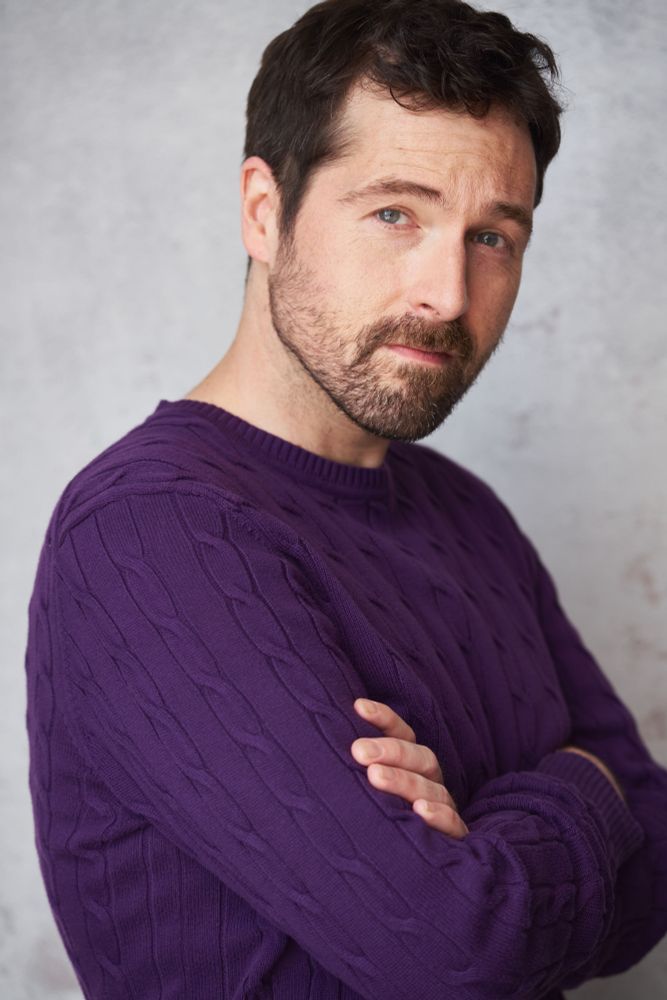Kyle in a purple Cosby sweater