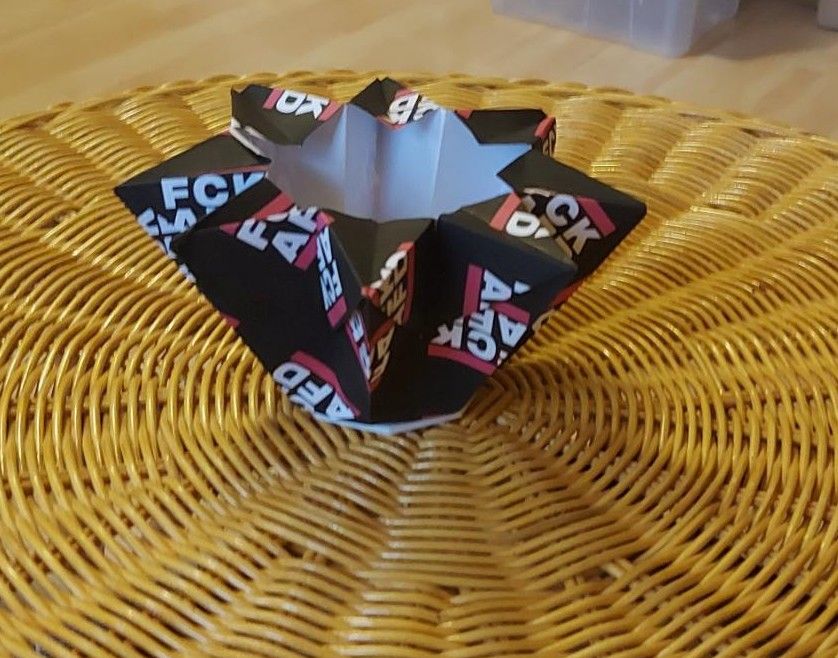 Origami Teelicht in Form eines Sterns, gebastelt aus "FCK AFD" Papier.