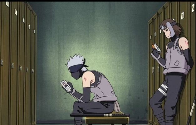 Kakashi and Tenzō in the ANBU locker rooms, Kakashi is say on the bench while Tenzō leans against the locker behind him, one hand folder behind his back. Both of them are reading booklets