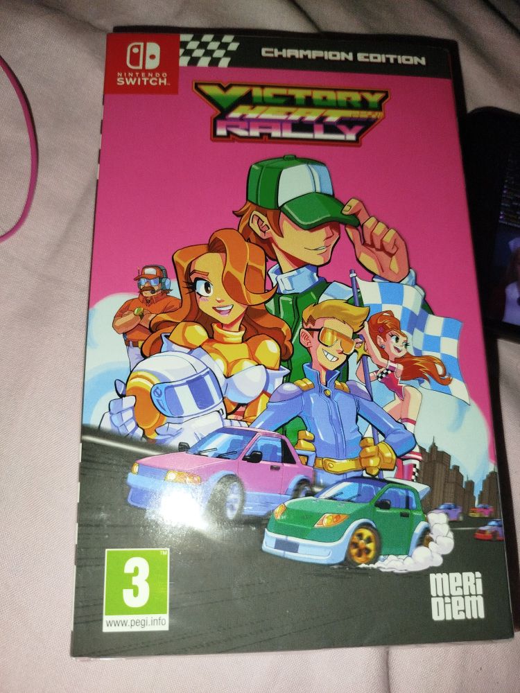 Portada del juego de switch del Víctor y Heat Rally Champion Edition. Es rosa con personajes y coches dibujados estilo cartoon