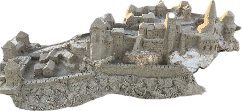 Eine Sandburg. Die Foto-app hat sie vor weißem Hintergrund „frei gestellt“, sodass sie ein wenig aussieht wie ein Papiermodell. 