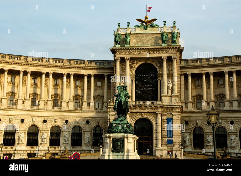 Foto der Wiener Hofburg vom Heldenplatz aus, der gesamte Bogen über dem "Altan" (auch bekannt als "Führerbalkon") ist ausgefüllt von einer schwarzen "Marmor"-Tafel mit der weißen Inschrift "Den Opfern des Nationalsozialismus" 