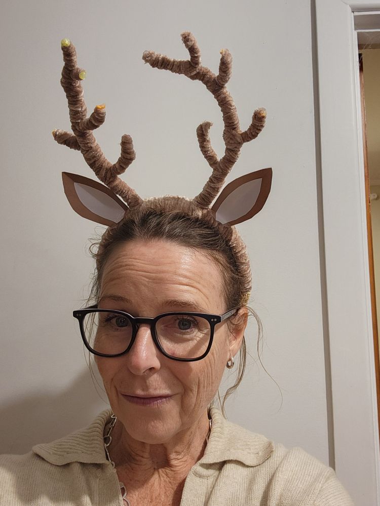 A middle-aged woman who ought to know better models a homemade reindeer antler headband complete with ears. 