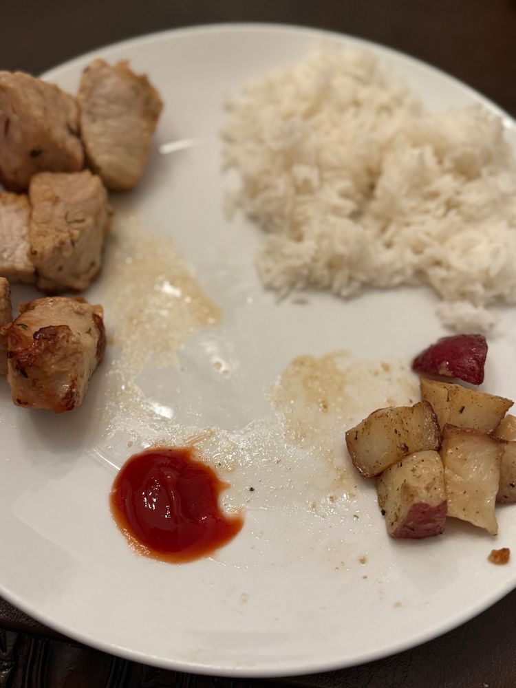 Pork, potatoes and white rice and also ketchup