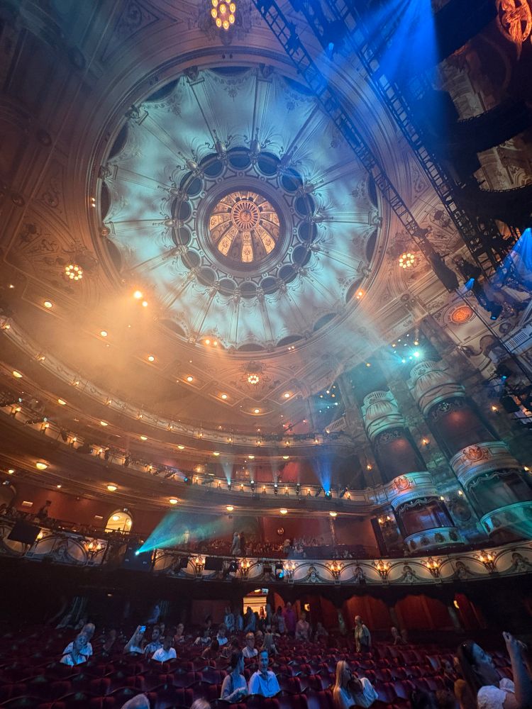 Im Inneren des London Coliseum. Blick auf die Decke und einen Teil der Sitzplätze im Parkett und in den Rängen.