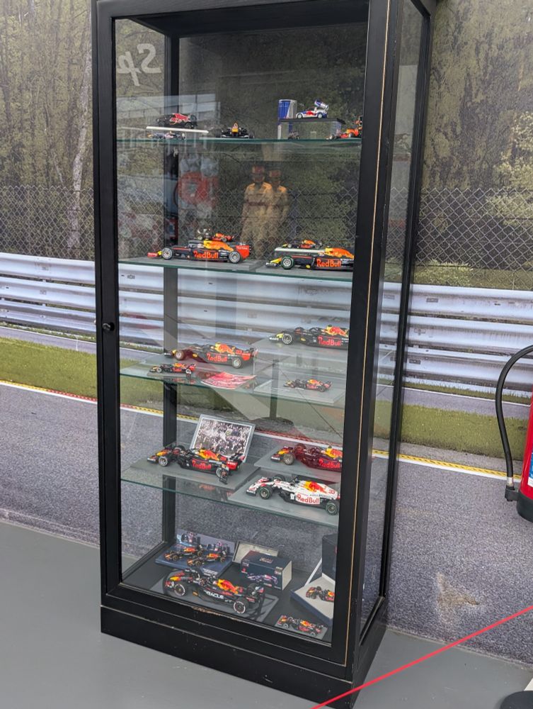 A cabinet filled with miniature model cars driven by Max Verstappen