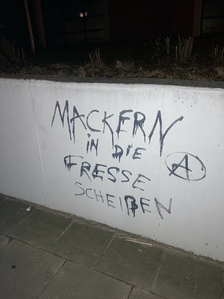 Wand auf der gesprüht steht:" Mackern in die Fresse Scheißen"