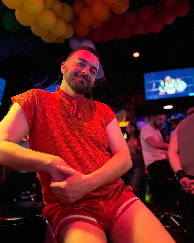 A man wearing a red short sleeved jersey top in red with red shorts that are way too damn short and showing too much 🫣