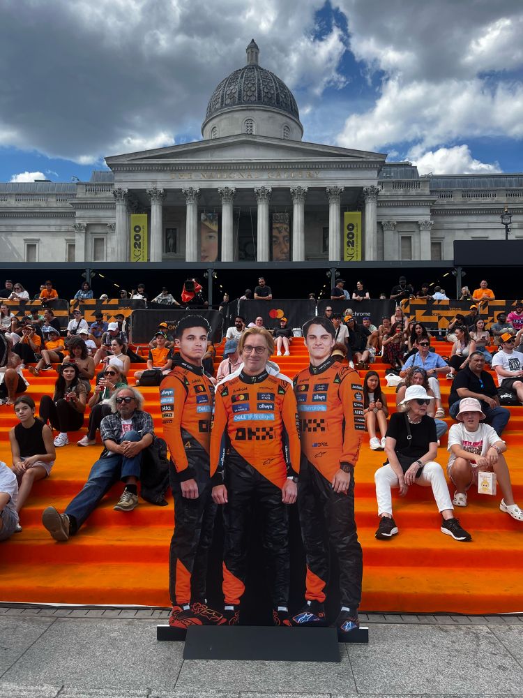 My head on a cardboard cut out as a McLaren Formula 1 driver alongside Lando Norris and Oscar Piastri. Behind are our adoring fans at an event in London’s Trafalgar Square.