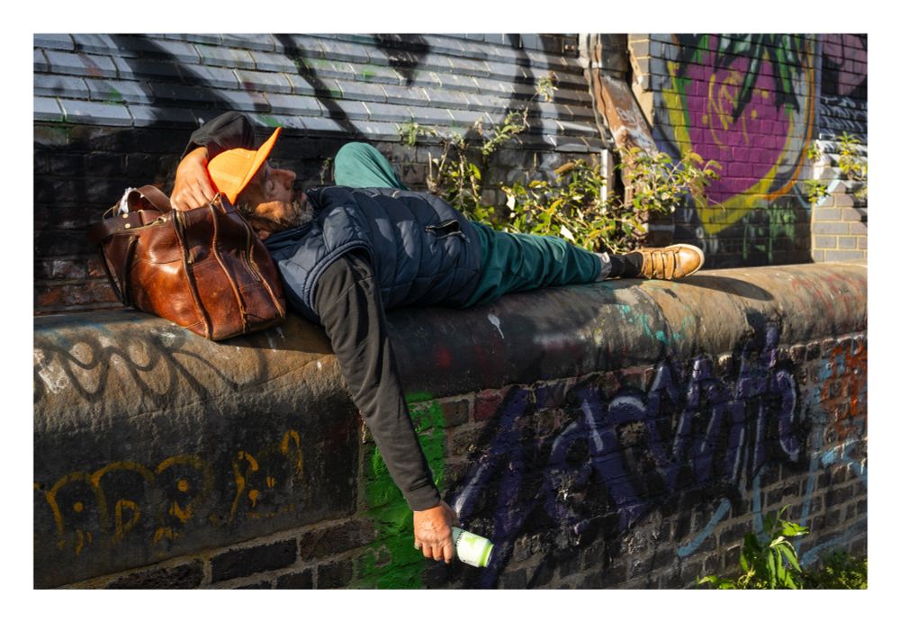 Man lazing on a wall in the sun in Camden, London