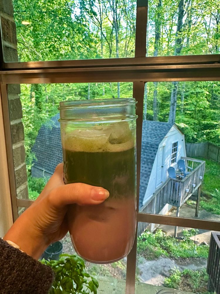 Mason jar with an iced strawberry oat milk matcha latte 