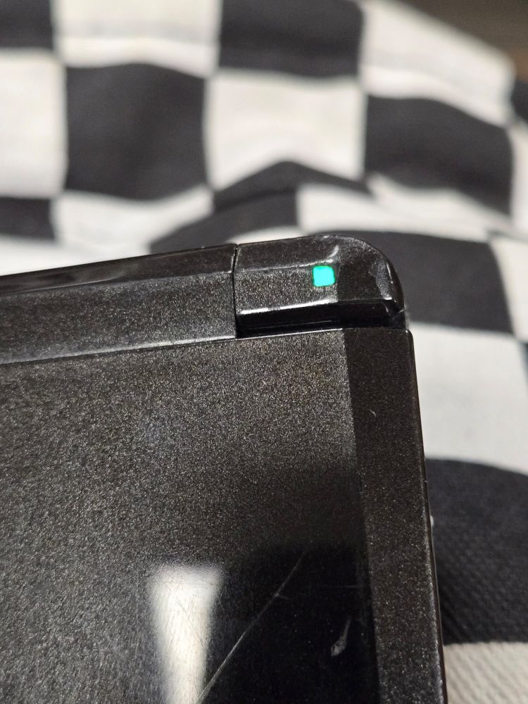 the top right corner light of a 3DS glowing green.