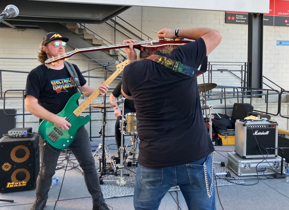 Photo of the guitarist for Electric Dynamite playing his guitar hoisted over his shoulders.