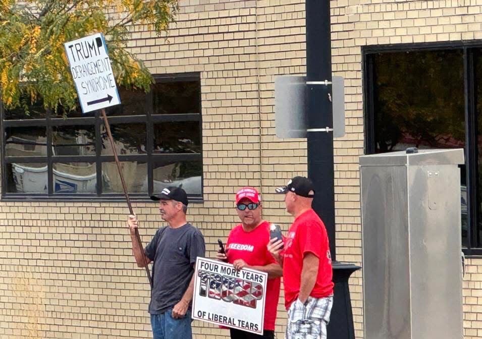 3 Pro-trump, counter protesters The sign on the left reads, “Trump Derangement Syndrome” with the arrow pointing at the other two counter protestors. 