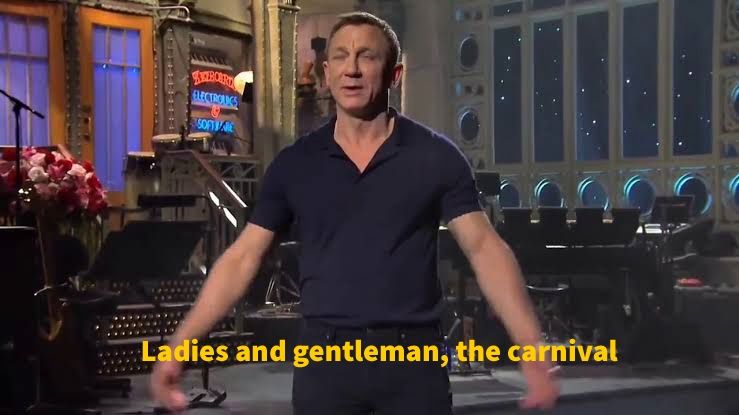 O ator Daniel Craig em um palco. A legenda diz "ladies and gentleman, the carnival" 