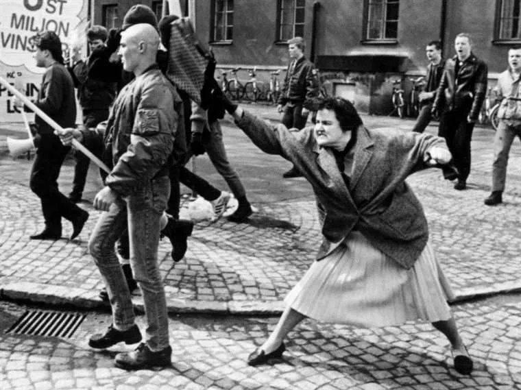 The Woman with the Handbag is a photograph taken in Växjö, Sweden on 13 April 1985 by photojournalist Hans Runesson. It depicts a 38-year-old woman, Danuta Danielsson, hitting a marching Neo-Nazi with a handbag. According to scholar Samuel Merrill, the photograph became popular for three reasons: it captures what Henri Cartier-Bresson called the "decisive moment" of an action or composition, it anticipates and insinuates rather than explicitly demonstrates violence, and it depicts what seems to be a vulnerable older woman confronting a young archetypal Neo-Nazi skinhead