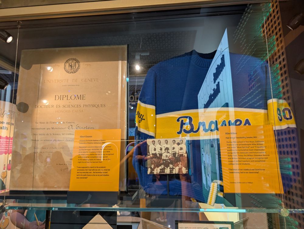 Photo of display from the Milken Center for the American Dream.

On the left is an honorary degree to Albert Einstein. On the right is Mike Milken's high school cheerleading sweater.