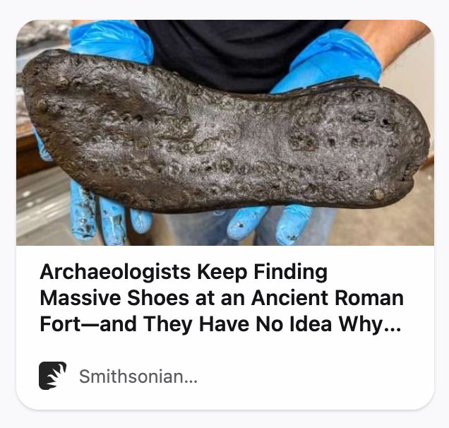 a screenshot of a smithsonian article headline that reads "archaeologists keep finding massive shoes at an ancient roman fort—and they have no idea why..."