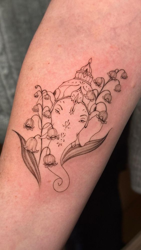 ein schwarz-weiß fine-line tattoo von Lord Ganesha umgeben von maiglöckchen