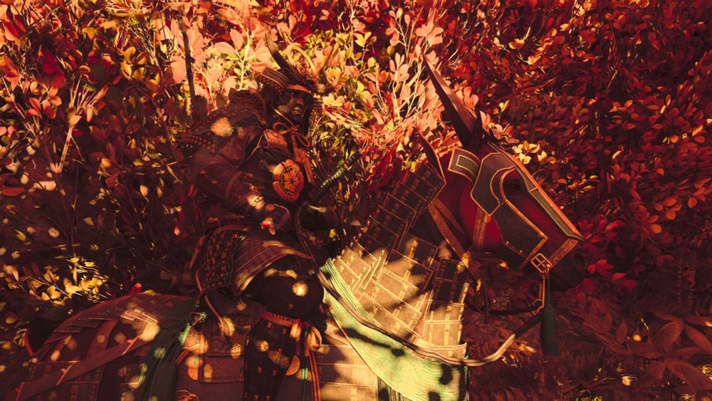 Yasuke astride his armoured horse, lit gold and red by the sunset amidst gold and red autumn leaves. 