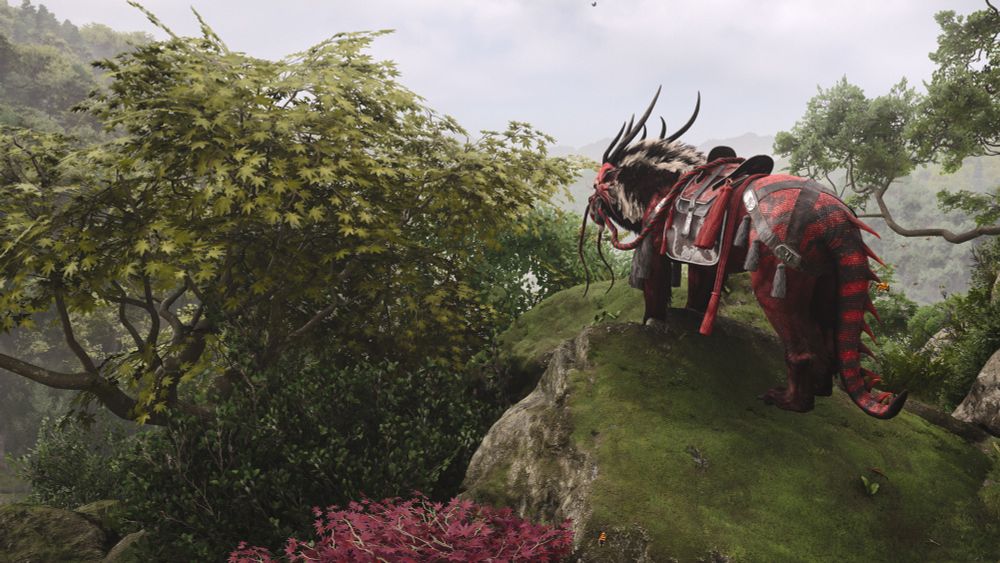 The red dragon with white and black fur and ropes and tassels on a rock overlooking a valley, red and green maple trees braid him.  