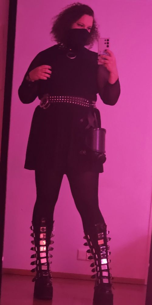 Me in all black outfit. There is a studded belt around my waist with a gas mask and handcuffs hanging from it.