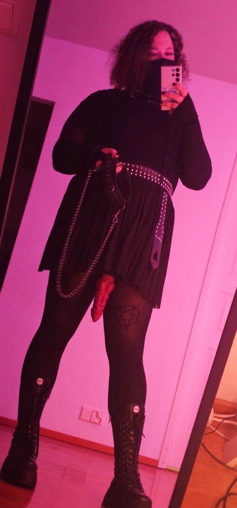 Selfie where i'm holding a chain leash with collar. There is a strap-on dangling between my legs.