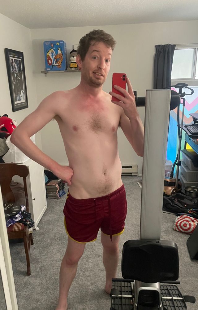 Mirror selfie of guy in red shorts next to a rower standing up.