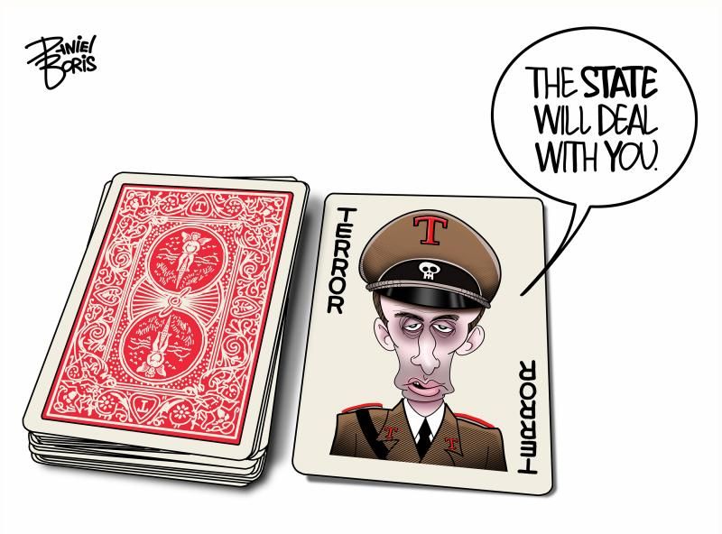 A political cartoon by Daniel Boris shows a deck of playing cards, with one card pulled out and facing up. The card depicts a caricature of a stern-looking man dressed in a brown military-style uniform with red trim and a cap featuring a skull insignia and the letter “T.” The text on the card reads “TERROR” along both vertical sides. The man on the card says in a speech bubble, “THE STATE WILL DEAL WITH YOU.” The rest of the deck lies face down, resembling standard red-backed playing cards. The image conveys an authoritarian theme, suggesting state repression or the use of fear and power against dissent.