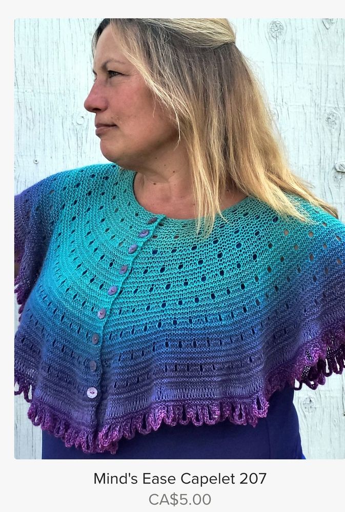 Jill wears a "Mind's Ease Capelet 207" worked in Blue Brick, Point Pelee Lace, colour Grand Turk. The buttoned, circular shawl is a gradient colour: turquois at the top  blue in the middle and purple on the loopy edge. 