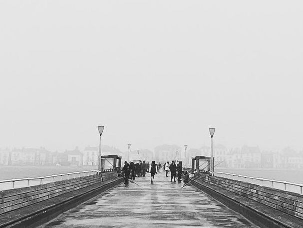 A black and white photo taken from the end of the pier in deal 