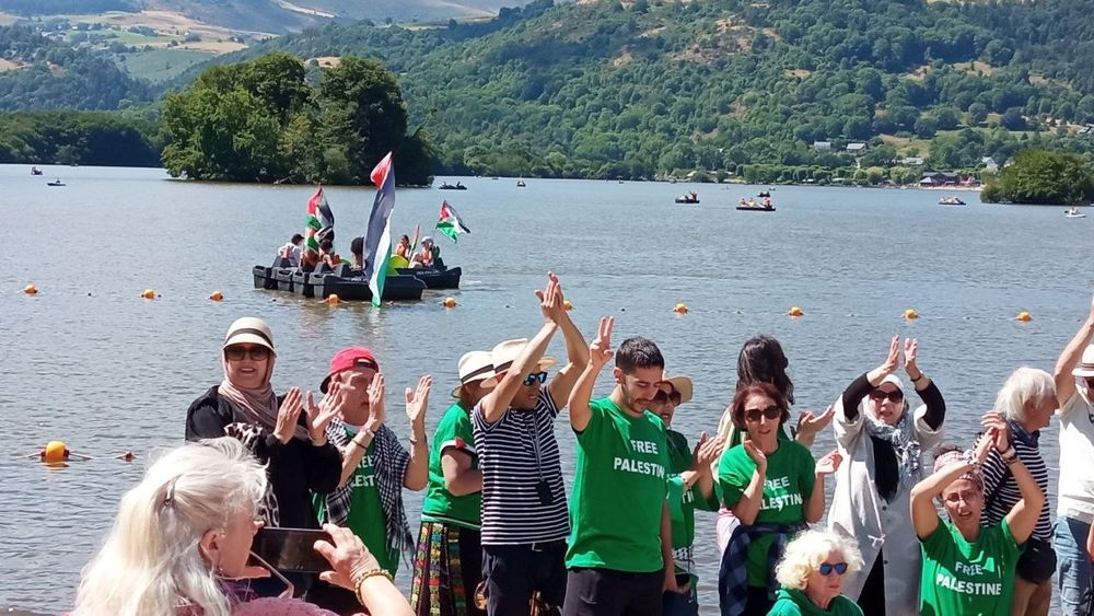 Photo d'une dizaine de personnes portant un tee-shirt "Free Palestine" devant le lac.