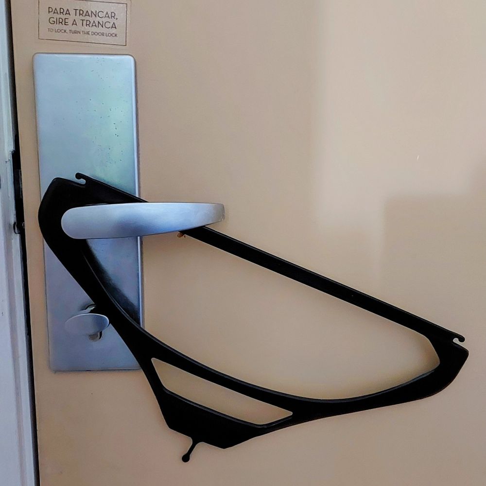 Maçaneta de porta de hotel com um cabide encaixado, de forma que não seja possível abrir a porta