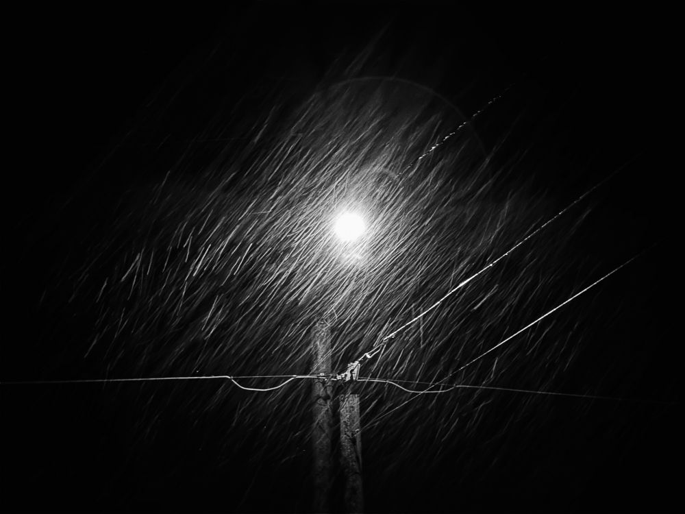 Snow streams in front of a street light