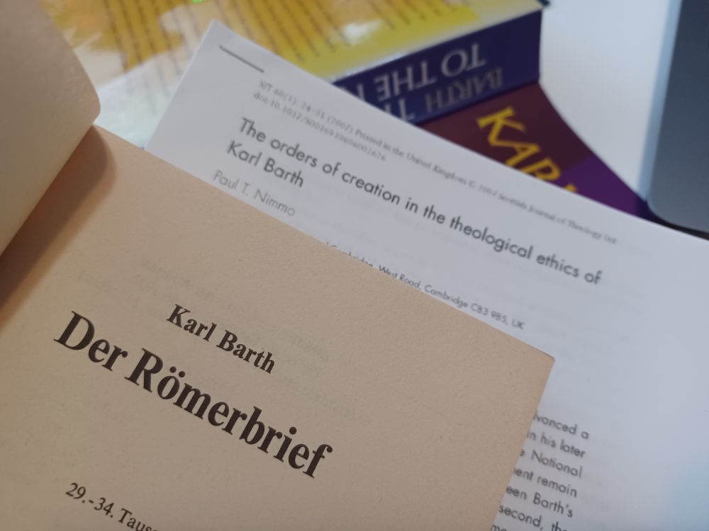 An open copy of Barth's Römerbrief in front of Paul Nimmo's essay on The Orders of Creation in Barth's Ethics