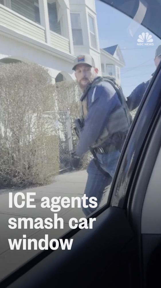 An ICE agent smashes a car window with the driver and his family inside. 