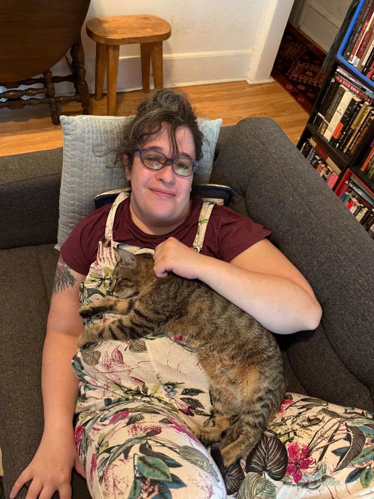 A happy Jonah with a sweet tiny cat laying on her chest