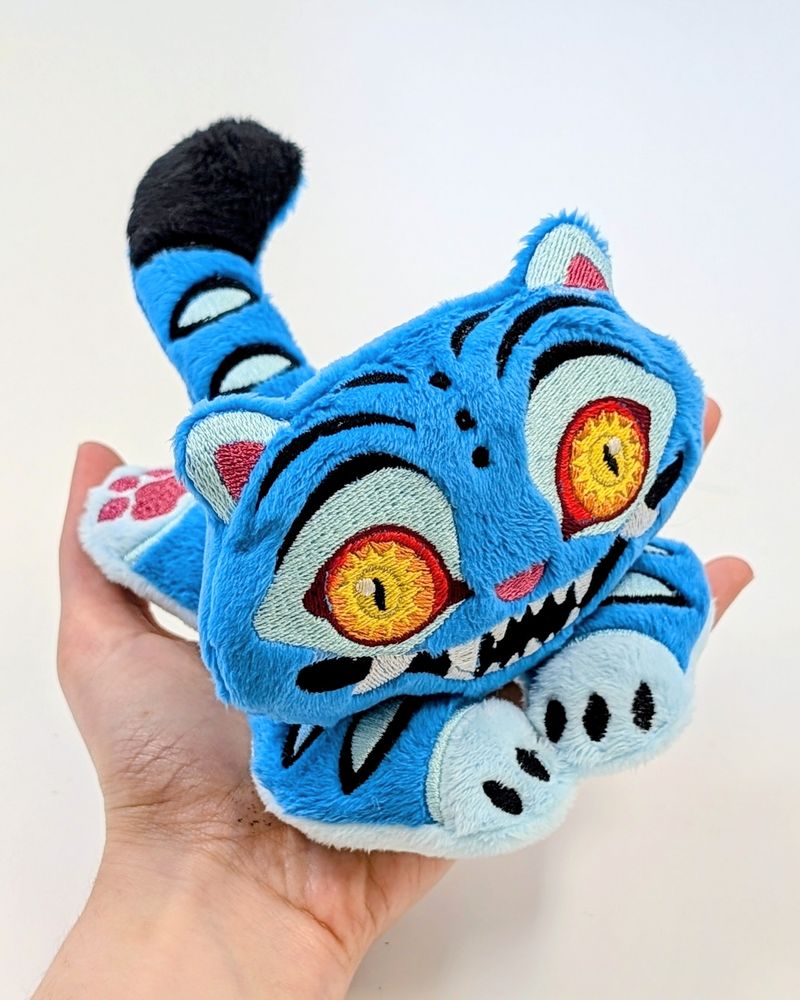 Photo of a plush of Derpy the tiger from Kpop Demon Hunters being held to show it's size
