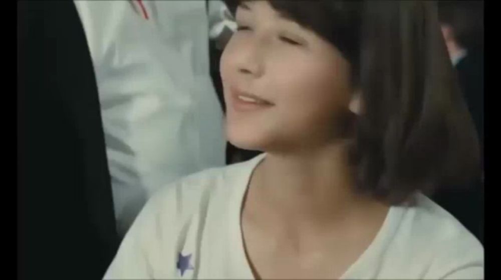 a young girl with short hair is smiling and looking at the camera .