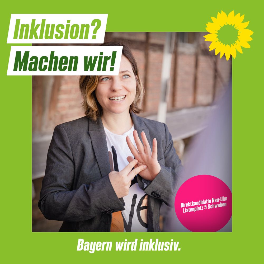 Julia hat kinnlange Haare. Über ihrem Gesicht steht: "Inklusion? Machen wir!" Und sie trägt ein T-Shirt und einen grauen Blazer. Sie gebärdet "Politik" Es ist auch ein pinker Kreis zu sehen wo steht: "Direktkandidatin der Grünen Neu-Ulm und Listenplatz 5 in Schwaben.