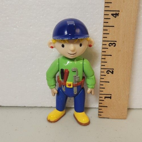 3.875 inch tall toy figurine construction worker next to a ruler.